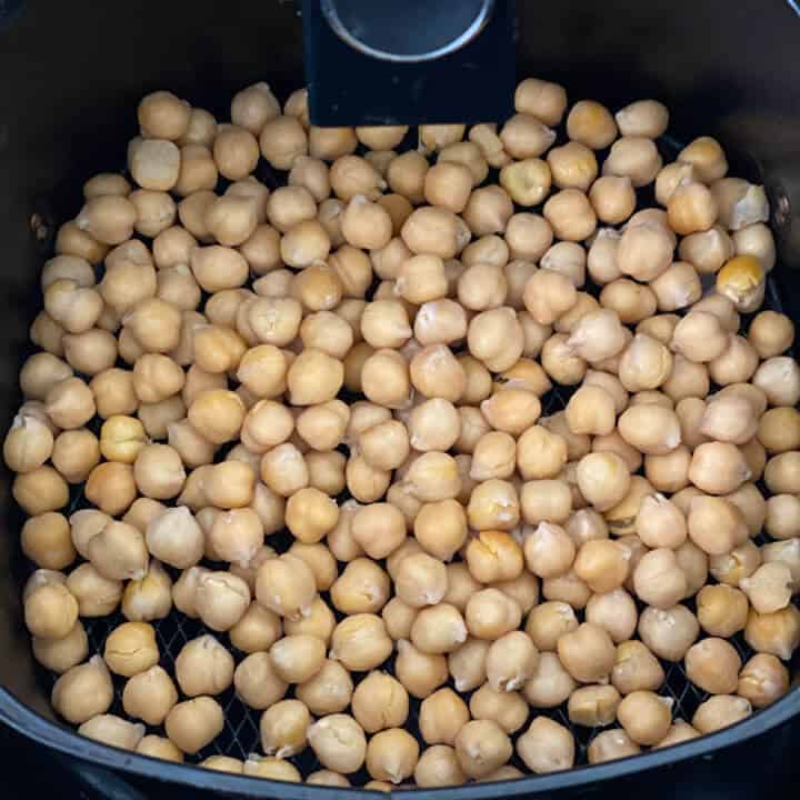 Uncooked chickpeas in the air fryer before roasting.