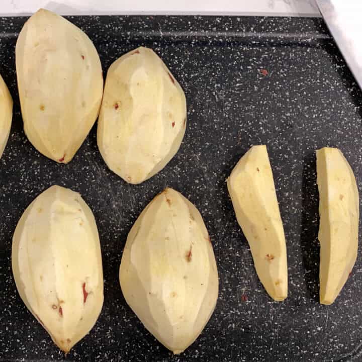 Peeled and cut sweet potatoes on a cutting board.