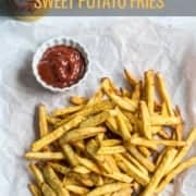 A parchment paper with a pile of sweet potato fries and a small white bowl in the top left corner and the words Crispy Sweet Potato Fries at the top.