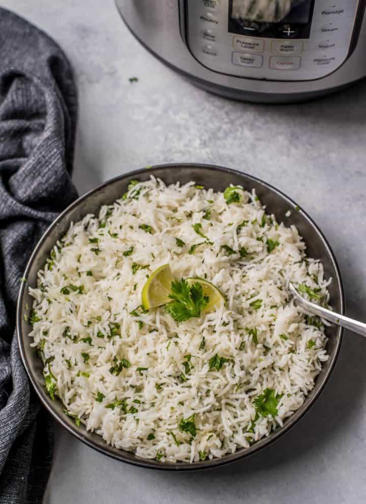 easy cilantro lime rice recipe in slate grey bowl with spoon and lime wedges