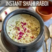 Rabdi in a black clay pot with nuts and rose petals as garnishes