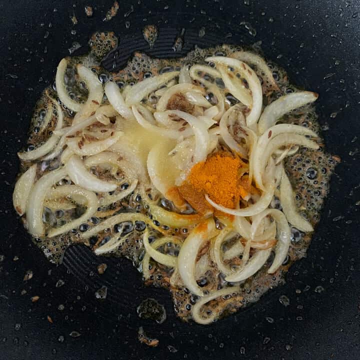 onions, turmeric powder and salt in a wok