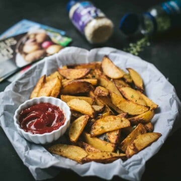 Air-fried potato wedges served on parchment paper with ketchup