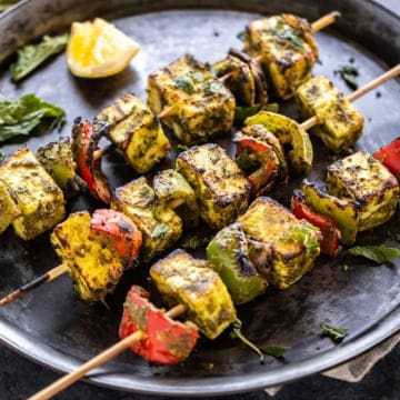 Hariyali paneer tikka served in a black plate