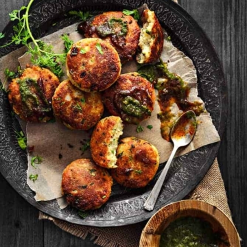 Paneer kabab served on a black plate with tamarind chutney