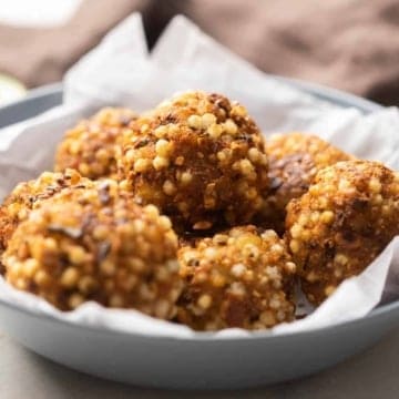 Sabudana vada served on a parchment paper kept over a grey bowl