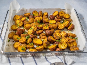 Fully cooked air fryer roasted baby potatoes, garnished with parsley.