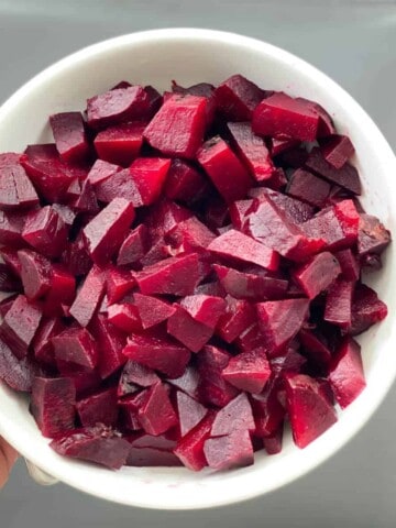 A white bowl with chopped beets after cooking in the instant pot.