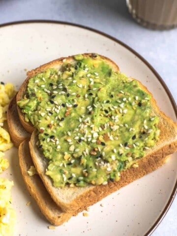 Two stack of toast, topped with avocado and everything bagel seasoning.