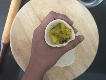Filling a dough cone with potato stuffing.