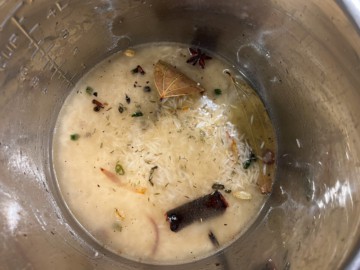 Adding water and additional aromatics to basmati rice.