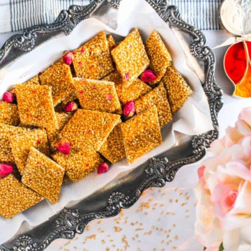 Sesame chikki placed on a rectangular metal plate