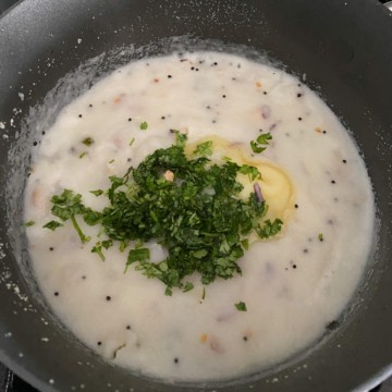 Cooked rava upma garnished with cilantro and topped with ghee