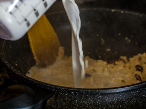 Adding milk to sooji ka halwa in a wok