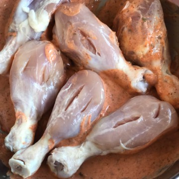 Slits cut into chicken placed in a marinade